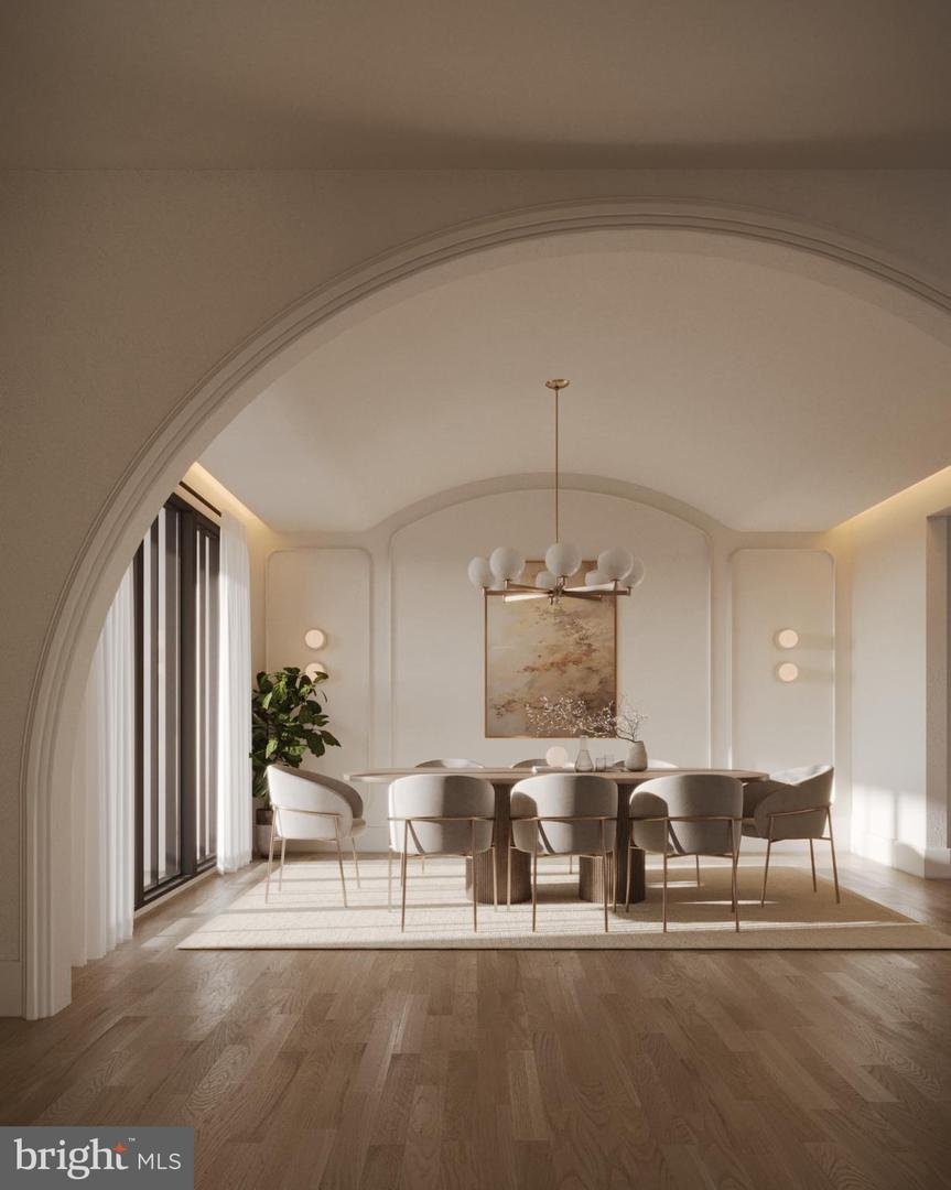 Rendering of the dining room seen through a tall plaster arch, with a round table, brass chandelier, and sheer curtains